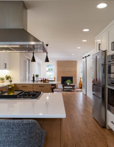 A modern kitchen with white cabinets and gray counter tops.