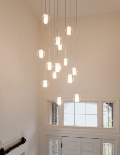 A chandelier hangs above a doorway in a home.