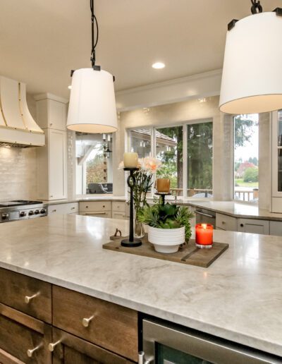 A kitchen with marble counter tops and a center island.