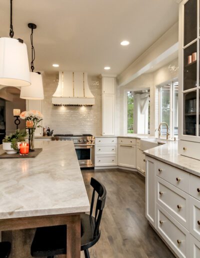 A kitchen with marble counter tops and a center island.