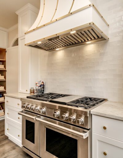 A kitchen with a stove and pantry.