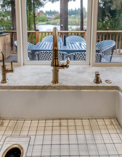 A kitchen with a large window and a marble sink.