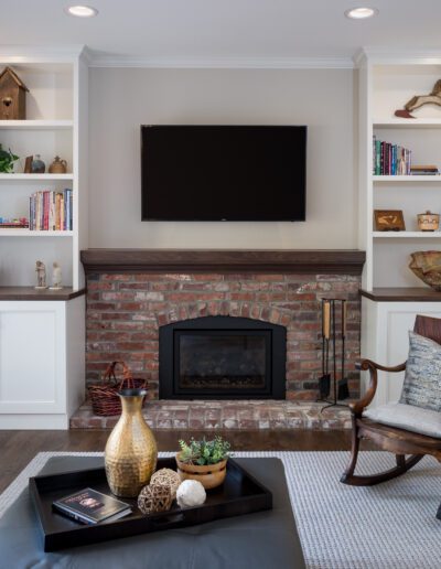 A living room with a rocking chair and a fireplace.