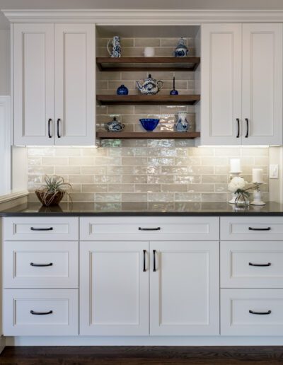 A kitchen with white cabinets and a wooden floor.