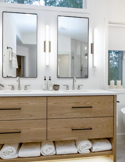 A modern bathroom with wooden cabinets and a bathtub.