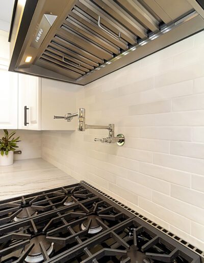 A white kitchen with stainless steel appliances.