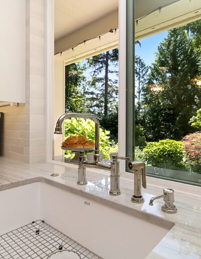 A kitchen with a large window and a sink.