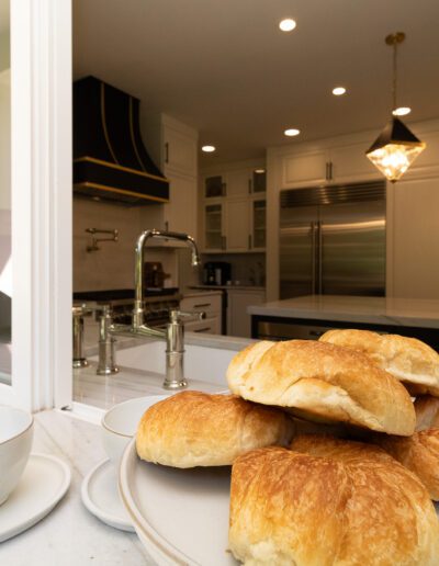 A plate of pastries and a cup of coffee on a kitchen counter.