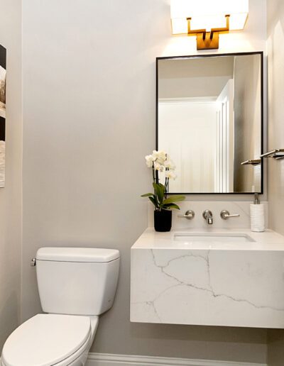 A bathroom with a toilet, sink and mirror.