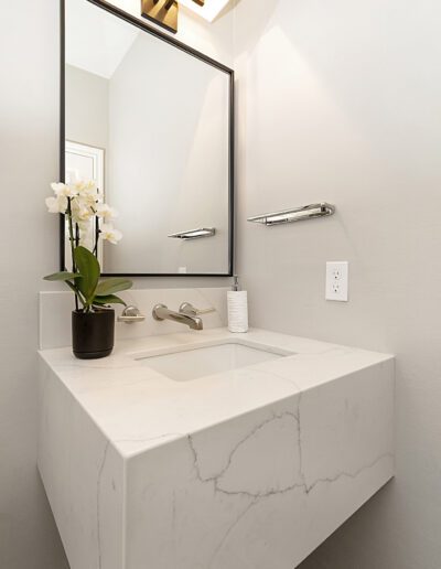 A bathroom with a white sink and mirror.