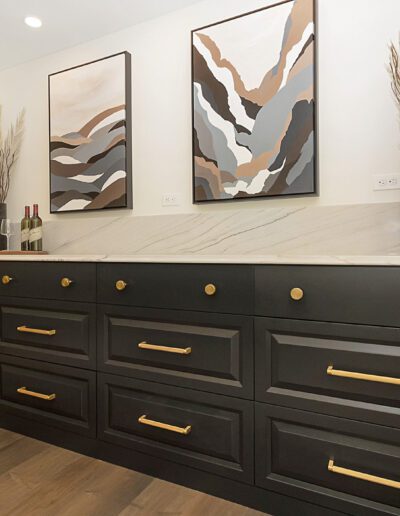 A black and gold dresser in a kitchen.